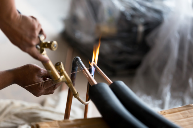 Technician welding copper pipe